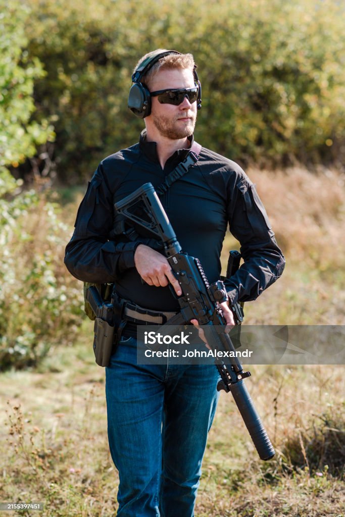 A man with a machine gun learns to shoot at a shooting range on a sunny day